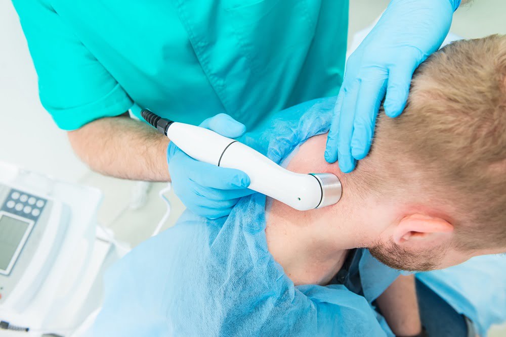 A chiropractor uses an adjustment tool on a patient's neck to provide targeted treatment and relieve tension - Chiropractor Meridian Idaho A chiropractor uses an adjustment tool on a patient's neck to provide targeted treatment and relieve tension - Chiropractor Meridian Idaho
